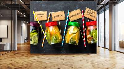 Variety of fruit infused detox water in jars for a healthy diet top view on a dark background Wall mural