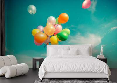 Child jumping with toy balloons in spring field Wall mural