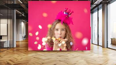 Fancy girl blowing confetti against pink bakground Wall mural