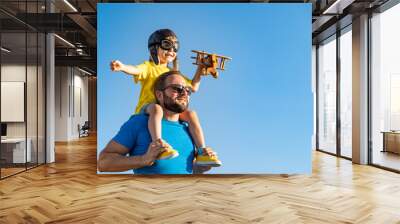 Father and son playing against blue summer sky background Wall mural