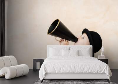 Funny child playing with black retro megaphone Wall mural