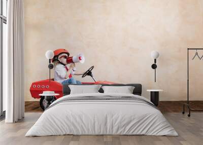 Funny kid driving toy car at home Wall mural