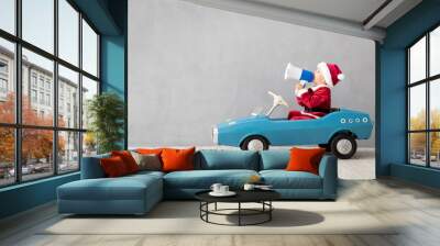 Happy child dressed Santa Claus costume playing at home Wall mural