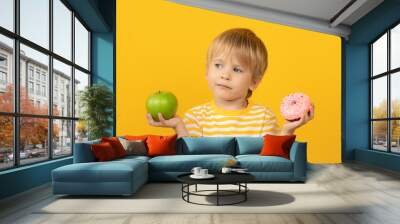 Happy child holding donut and apple Wall mural