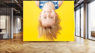 Happy child shouting against yellow paper background Wall mural