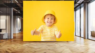 Portrait of happy child against yellow background. Summer vacation concept Wall mural