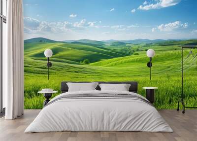 Beautiful rolling green hills under a clear blue sky with scattered white clouds, showcasing a serene and picturesque countryside landscape. Wall mural