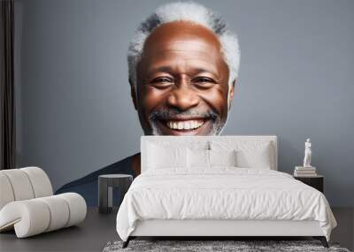 Handsome black senior man with white hair, smiling to camera on grey background, displaying vibrant health with great skin and teeth Wall mural