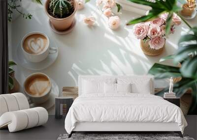 Flat lay table with two white coffee cups, a pen, and a vase of flowers surrounded by potted plants, creating a cozy and inviting atmosphere Wall mural