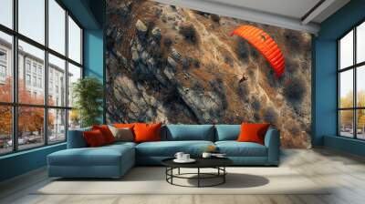 Flying a parachute on a rocky hill. Aerial view Wall mural