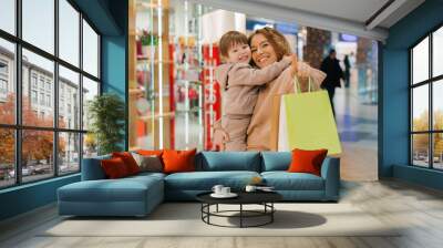 Happy family mom and little son with shopping bags at sales in the mall. Shopping with children Wall mural