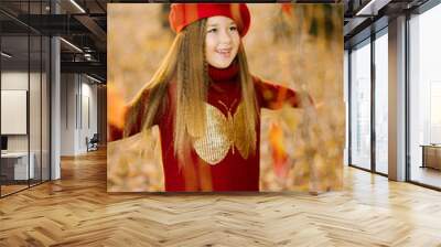 Happy six year old girl in a red beret throws up autumn yellow leaves and laughs Wall mural