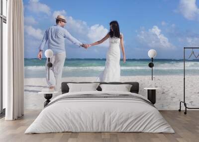 Beautiful couple on the beach in wedding dress Wall mural