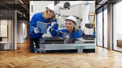 Female automation engineer wear vest with helmet safety checking and inspection control robot arm machine in an industrial factory. Artificial intelligence concept Wall mural