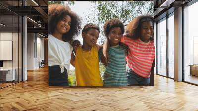 Happy african kids smiling and embracing together in the park Wall mural