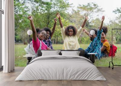 Happy fun group of African American children raised hands together in the park, Education outdoor concept Wall mural