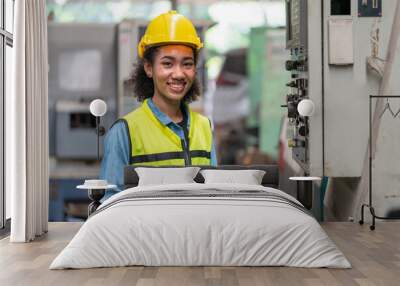 portrait asian female engineer with yellow helmet using tablet working operating machine at factory  Wall mural