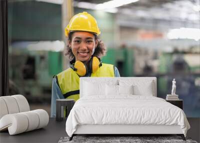 Portrait of female engineer in safety vest with yellow helmet smiling stand to work at factory Industrial Wall mural