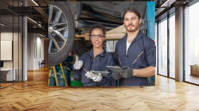 Portrait of Mechanics man and woman holding tablet looking at camera after working check and repair maintenance a car in auto service garage Wall mural