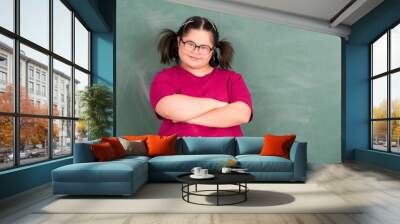 Portrait of young Asian disabled child down's syndrome girl student in happy and smile emotion in front of chalkboard in element classroom Wall mural