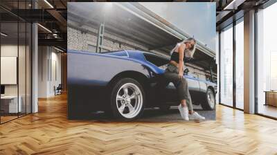 Beautiful Caucasian female posing with an old classic retro muscle car. Automotive lifestyle Wall mural