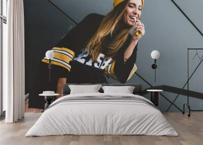 outdoor lifestyle portrait of pretty sexy lookin young girl in hockey jersey style dress posing on g Wall mural