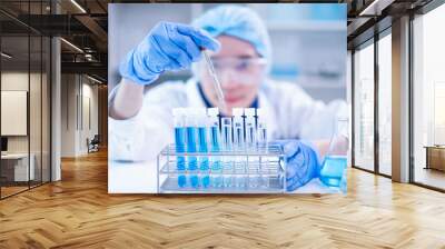 Professional scientist chemist technician analysis research experiment virus blue liquid pipette glass test tube equipment in hospital laboratory, woman doctor white lab coat medical research develop Wall mural