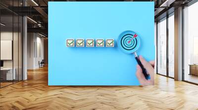 Business Strategy Planning and Quality Management Concept. Magnifying glass focuses on target icon and blocks with check marks. business goal setting, strategy planning, quality management processes, Wall mural