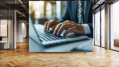 Businessman typing on a laptop keyboard at a white office desk, close-up of hands with a tie and suit, working in a modern technology lifestyle concept. Wall mural