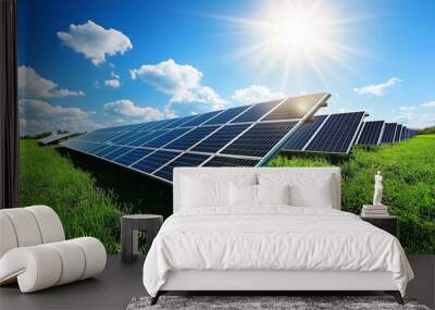 A close-up modern photograph of solar panels in a green field, with a blue sky and the sun shining on them. Wall mural