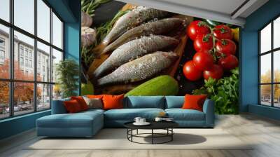 four fresh raw dorada fish on a wooden board with a set of vegetables on a black table Wall mural