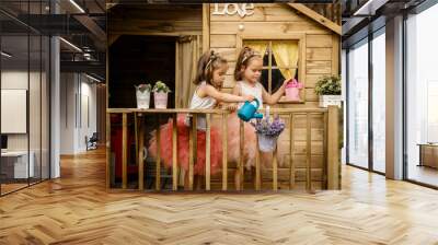 Two girls play with watering can in a tree house Wall mural