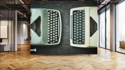 two old typewriters on a black wooden table Wall mural