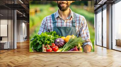 Charming male farmer holding a crate full of fresh vegetables in the farm garden. Wall mural