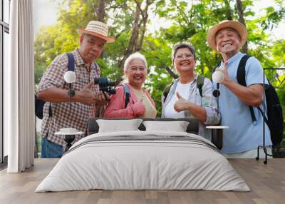 Portrait of a group of Asian elderly people traveling in a natural forest. They give thumbs up, likes and happy smiles. Elderly community Wall mural