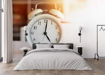 The white clock tells the morning at 5:00 am or evening 17.00 pm, resting on the white table in the room. Wall mural