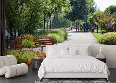 Rest area with bench surrounded by blooming flowers and ornamental shrubs in Kyiv, Europe. Place to rest in the city park Wall mural