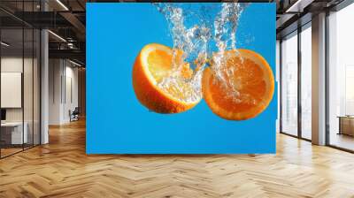 Two halves of an orange falls into the water with Wall mural