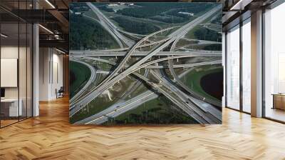 Aerial perspective of a highway interchange, with multiple lanes, ramps, and overpasses converging in a complex network Wall mural