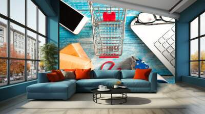 Online business concept.  Shopping cart with boxes and smartphone on table Wall mural