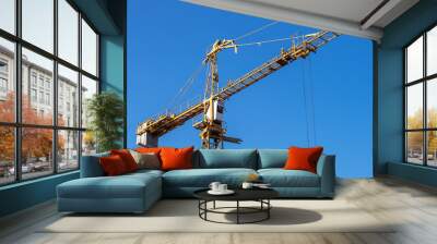 real high yellow crane tower isolate on blue sky background Wall mural