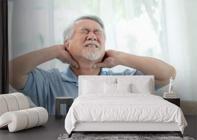 Senior Asian man , old man he wake up and sat on the bed , He had pain in the nape of his neck caused by sleeping on a pillow that is not correct posture - Senior people unhealthy diseased concept Wall mural