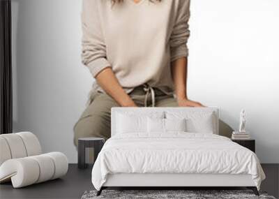 A woman in relaxed attire sitting on a stool Isolated Wall mural