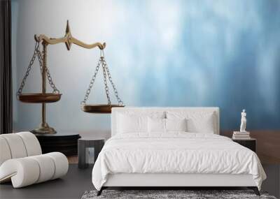 Brass balance scales on a wooden table against a blue background, symbolizing justice and fairness. Wall mural