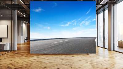 Modern highway cutting through Asian countryside under a clear blue sky Wall mural