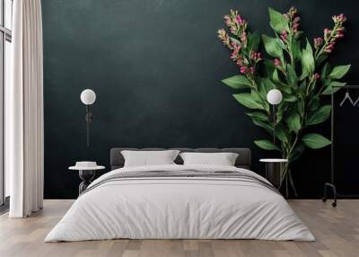 A bouquet of flowers with pink blooms and green leaves on a dark surface. Wall mural