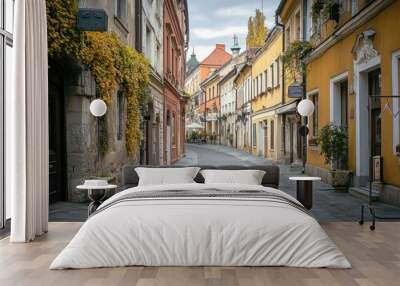 A charming cobblestone street lined with colorful buildings and greenery. Wall mural