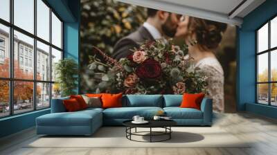 A couple shares a kiss, with the bride holding a beautiful bouquet of flowers. Wall mural