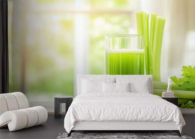 A glass of green celery juice beside fresh celery stalks on a wooden table. Wall mural