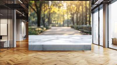 A marble table in a sunlit park setting with trees and a pathway in the background. Wall mural